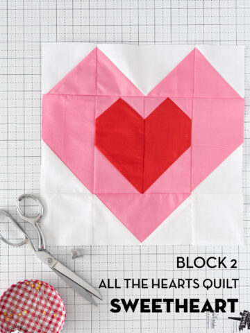 Pink and red heart quilt block on white cutting mat
