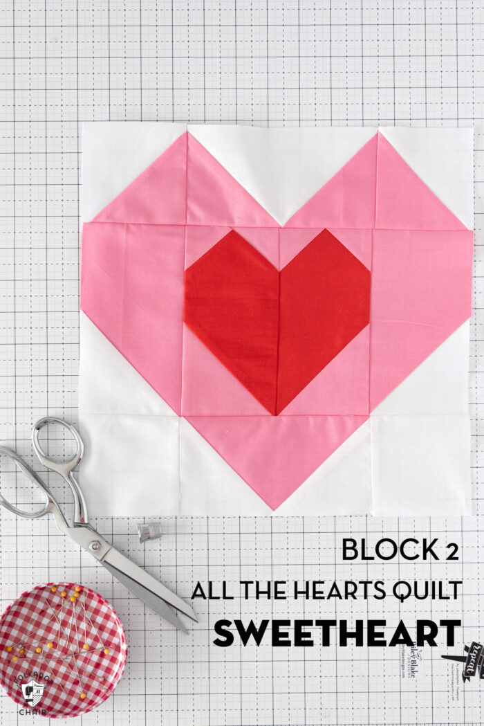 Pink and red heart quilt block on white cutting mat