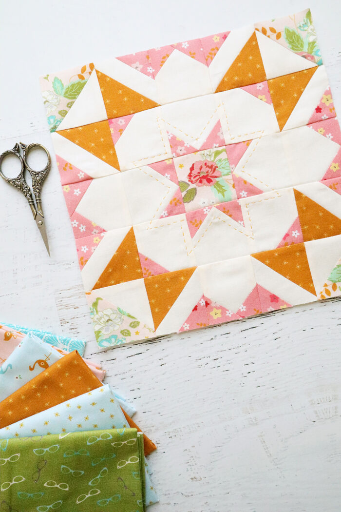 pink, orange and green quilt block on white table