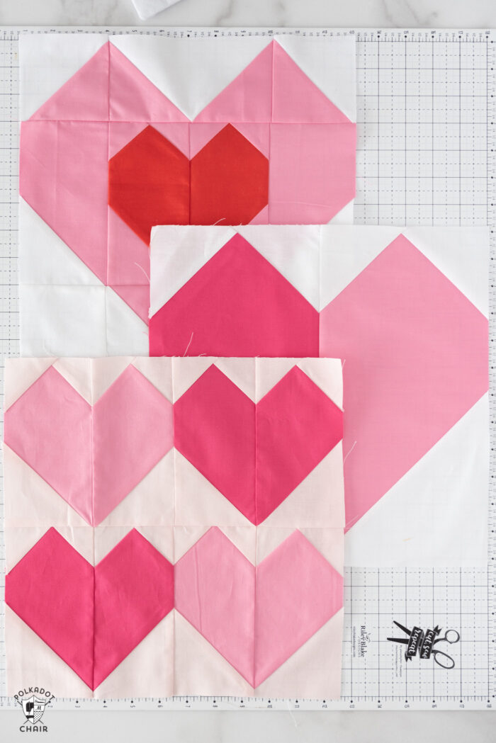 Pink and red heart quilt blocks on white cutting mat