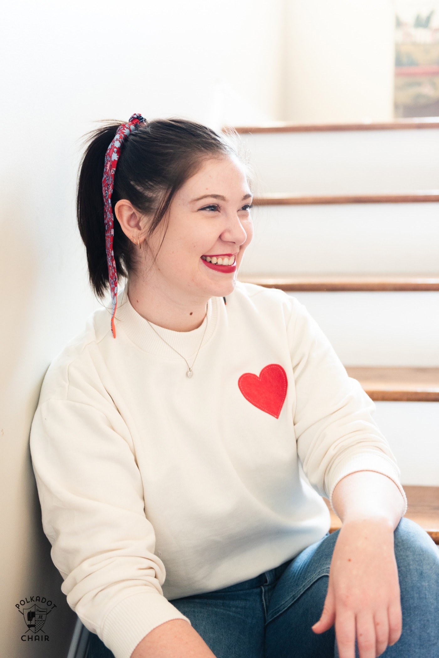girl wearing cream sweatshirt with red heart
