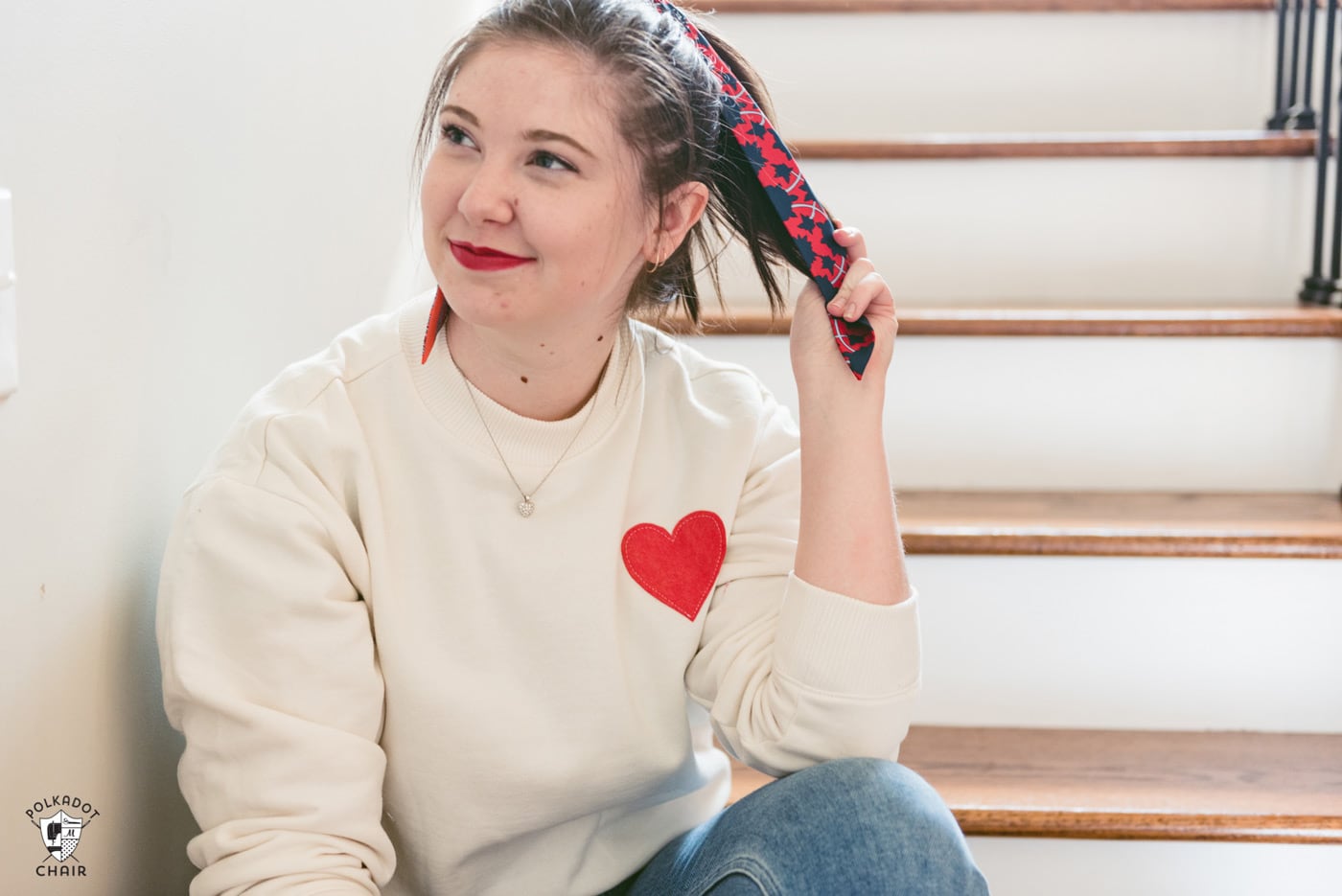 girl in ivory heart sweatshirt sitting on stairs