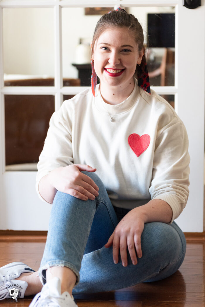 girl in ivory heart sweatshirt sitting on floor