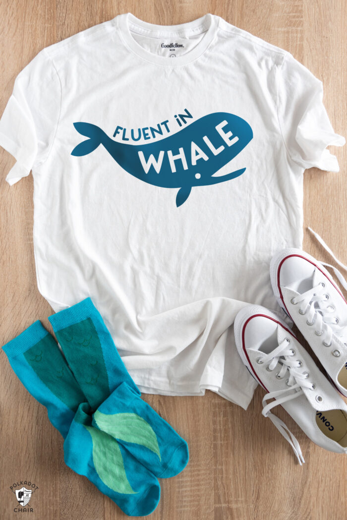 white shirt with blue lettering, socks and shoes on wood table