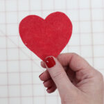 hand holding red cut out heart