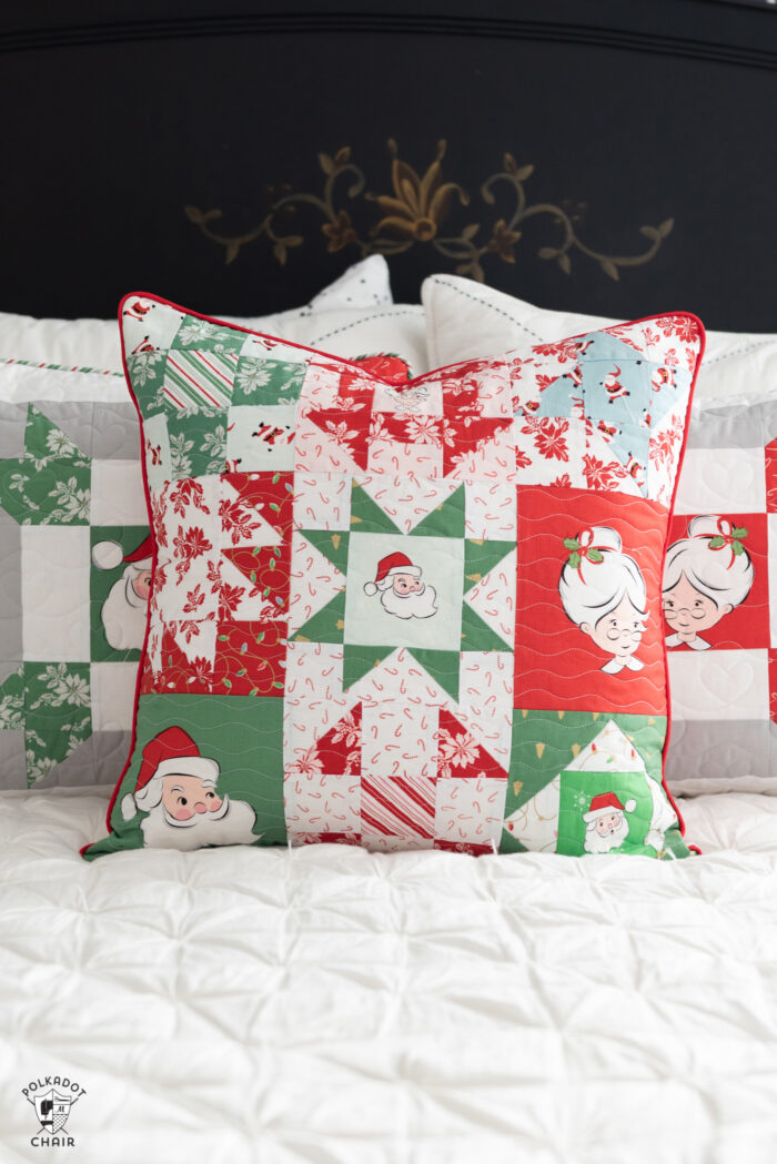 red, green and white patchwork christmas pillows on white bed