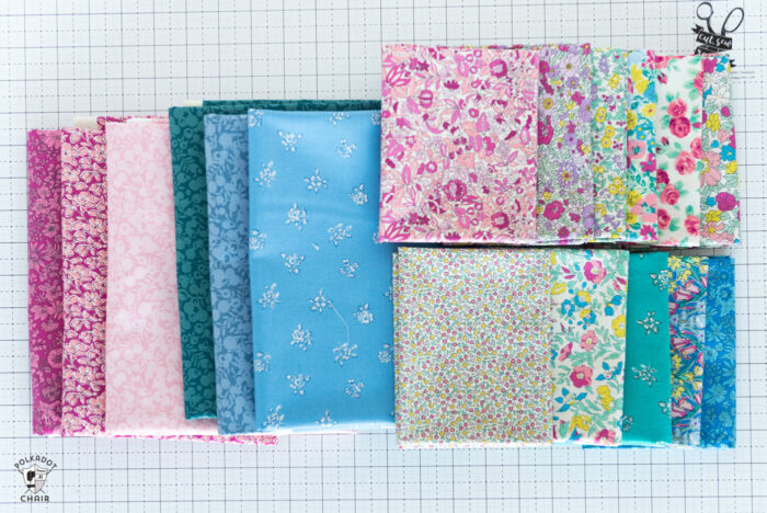 various bright colors of flat folds of liberty fabrics on white cutting mat