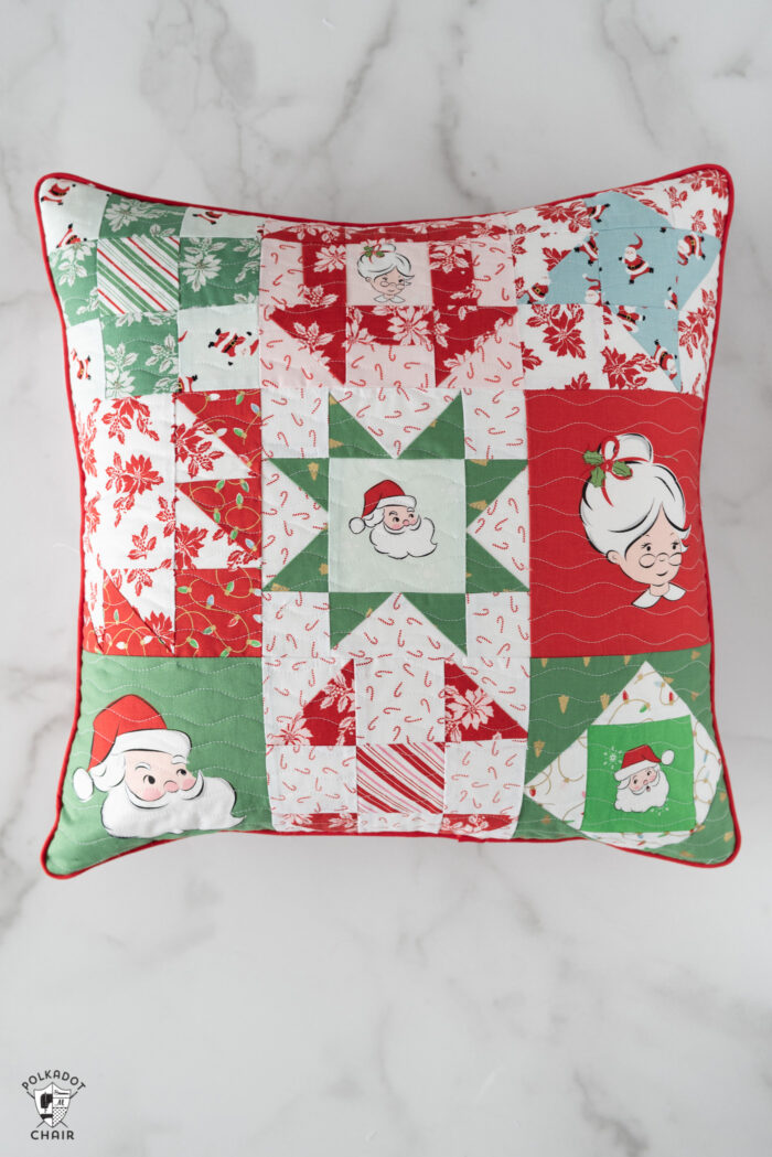 red, green and white patchwork christmas pillows on white tabletop