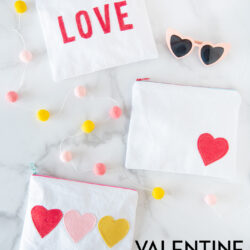 white canvas zip pouches with red lettering and hearts on white tabletop