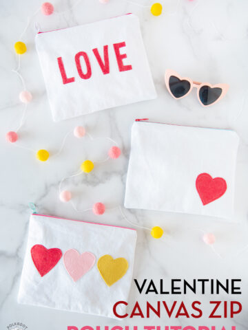 white canvas zip pouches with red lettering and hearts on white tabletop