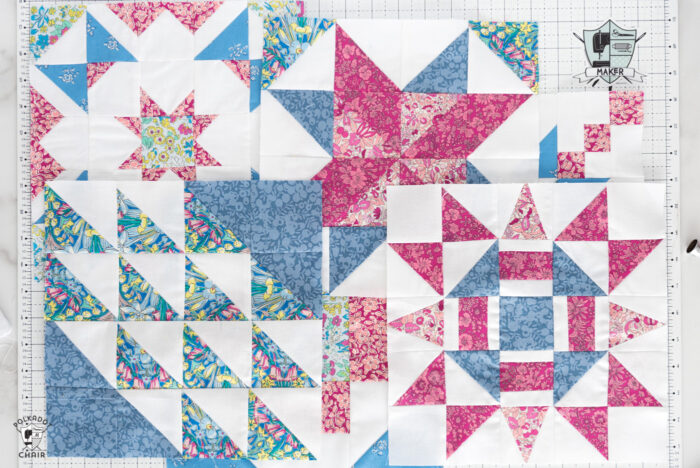 multiple red pink and white quilt blocks on white cutting mat