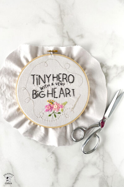fabric in embroidery hoop with scissors