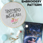 book and embroidery hoop on white table