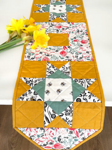 yellow, and green floral table runner on white table with flowers