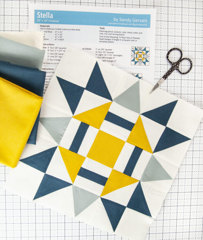 blue and yellow quilt block on white cutting mat