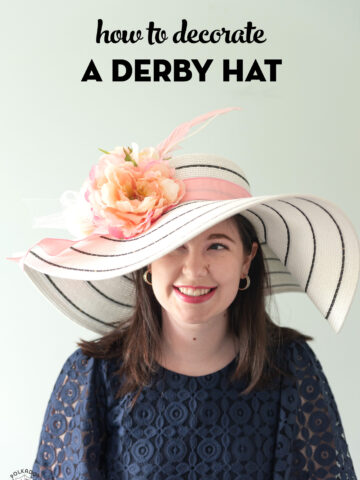 girl in white derby hat with pink flowers wearing a navy dress