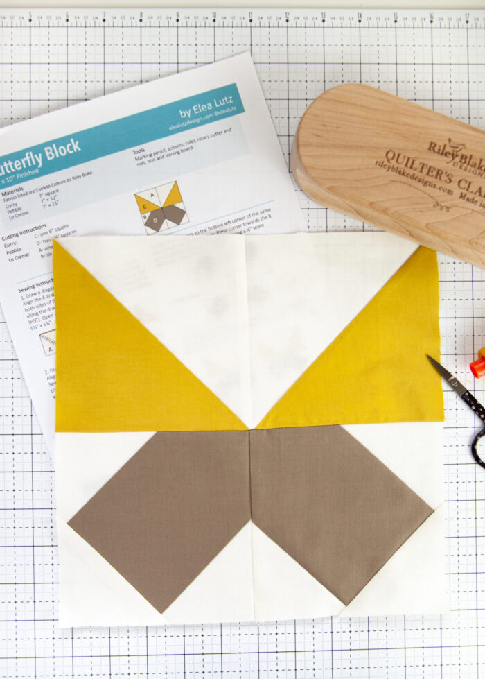 mustard yellow and taupe quilt block on white cutting mat