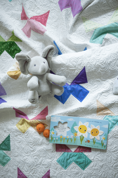 stuffed animal on white quilt with colorful butterfly blocks