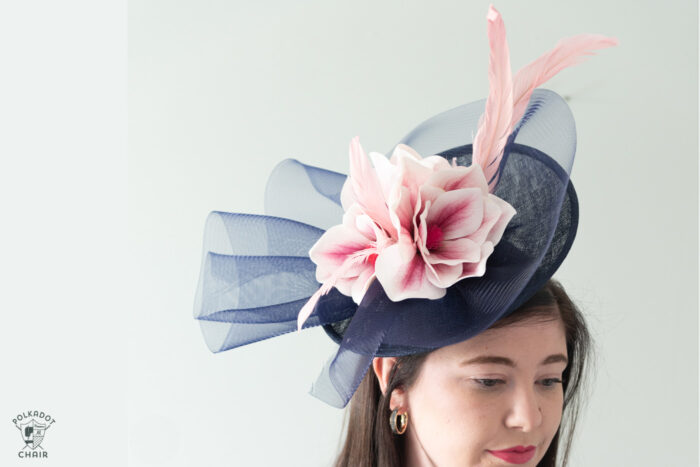 girl in navy dress wearing navy fascinator with pink flowers