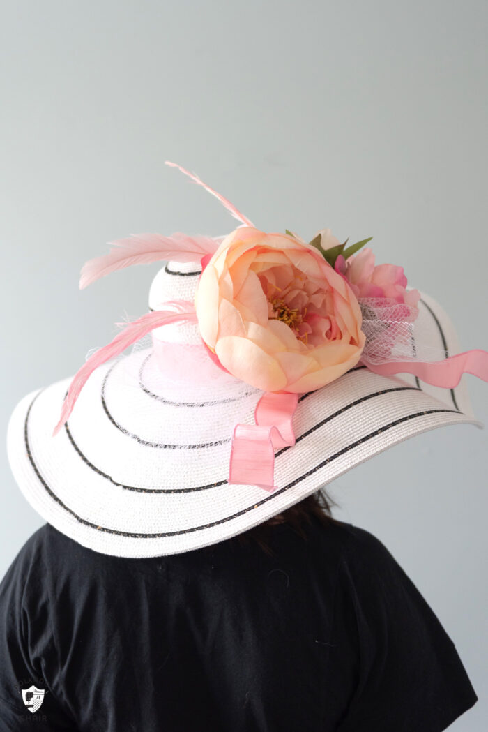 girl in white derby hat with pink flowers wearing a navy dress