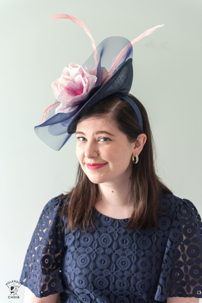 girl in navy dress wearing navy fascinator with pink flowers