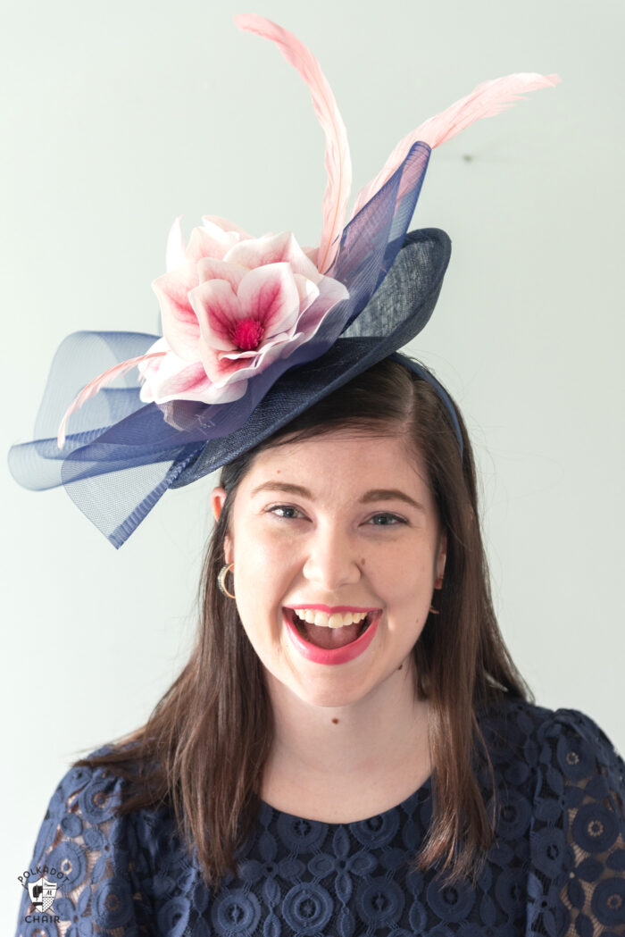 girl in navy dress wearing navy fascinator with pink flowers