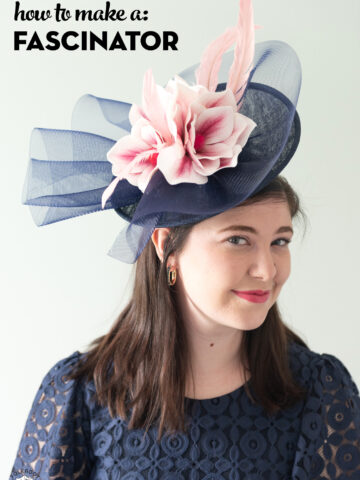 girl in navy dress wearing navy fascinator with pink flowers