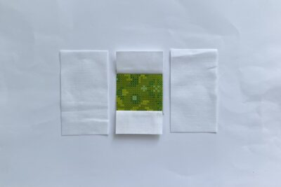 cut white and green fabric on white table
