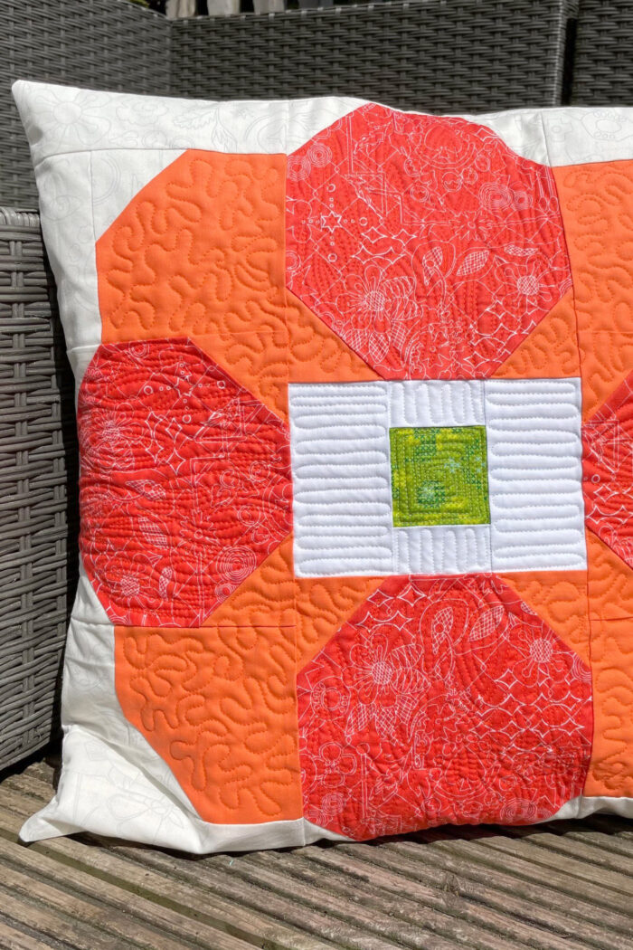 photo of orange and cream quilted pillow outdoors