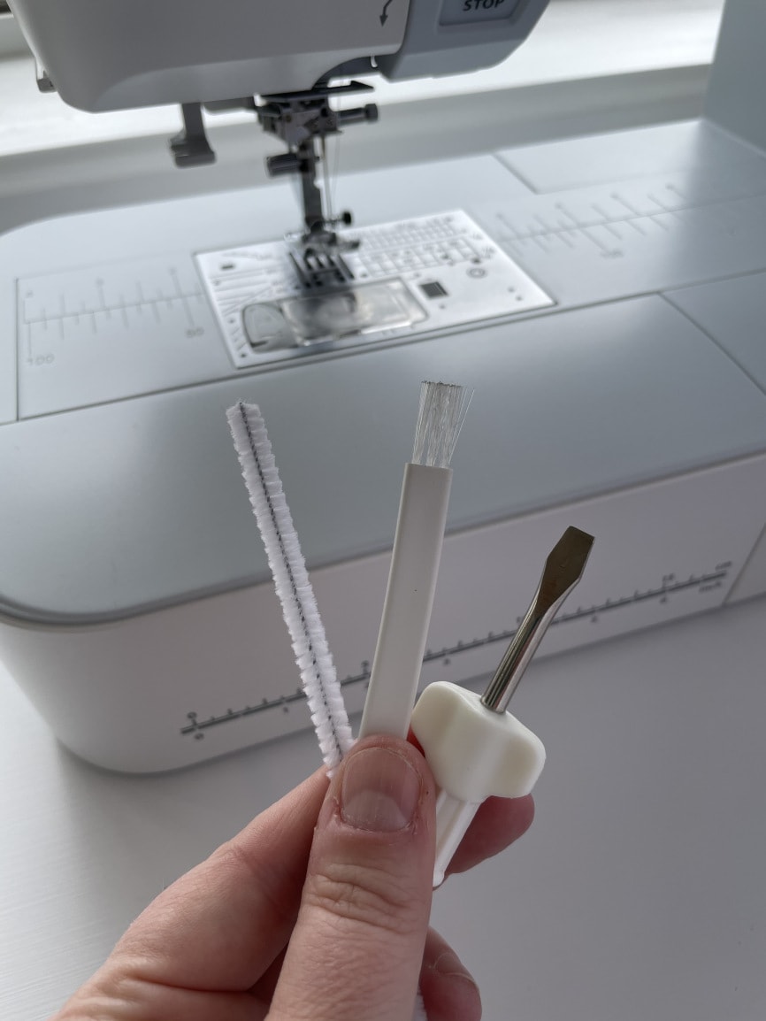 hand holding tools of sewing machine