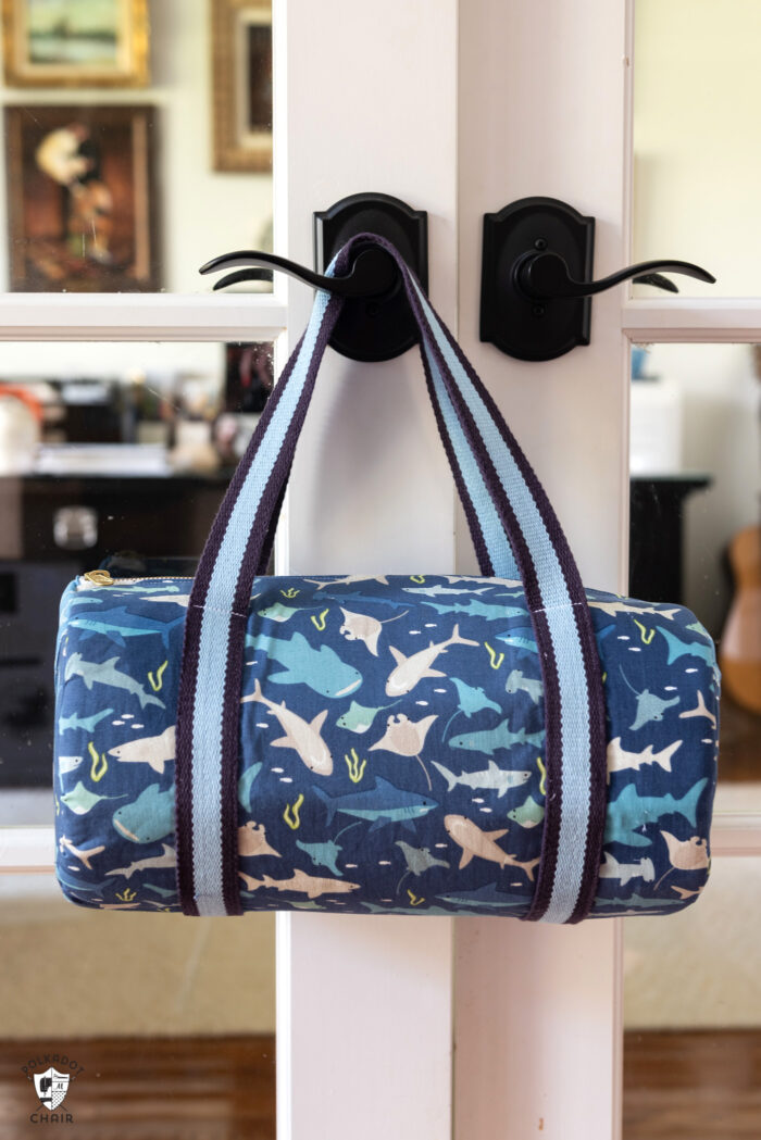 Blue duffle bag hanging on door handle