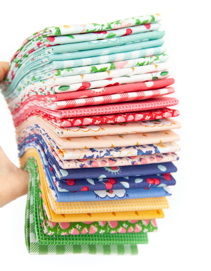 hand holding stack of colorful folded fabric