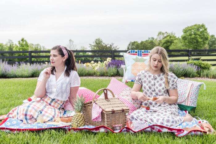 two girls on picnic blanket outdoors