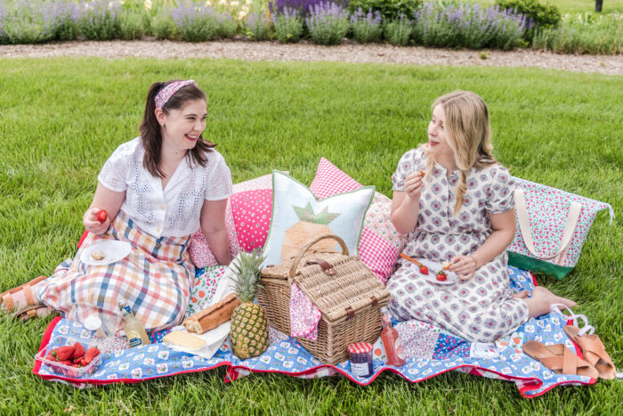 two girls on picnic blanket outdoors