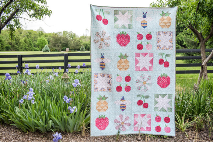 quilt hanging in front of garden