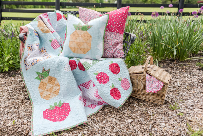 picnic basket and quilt on bench outdoors