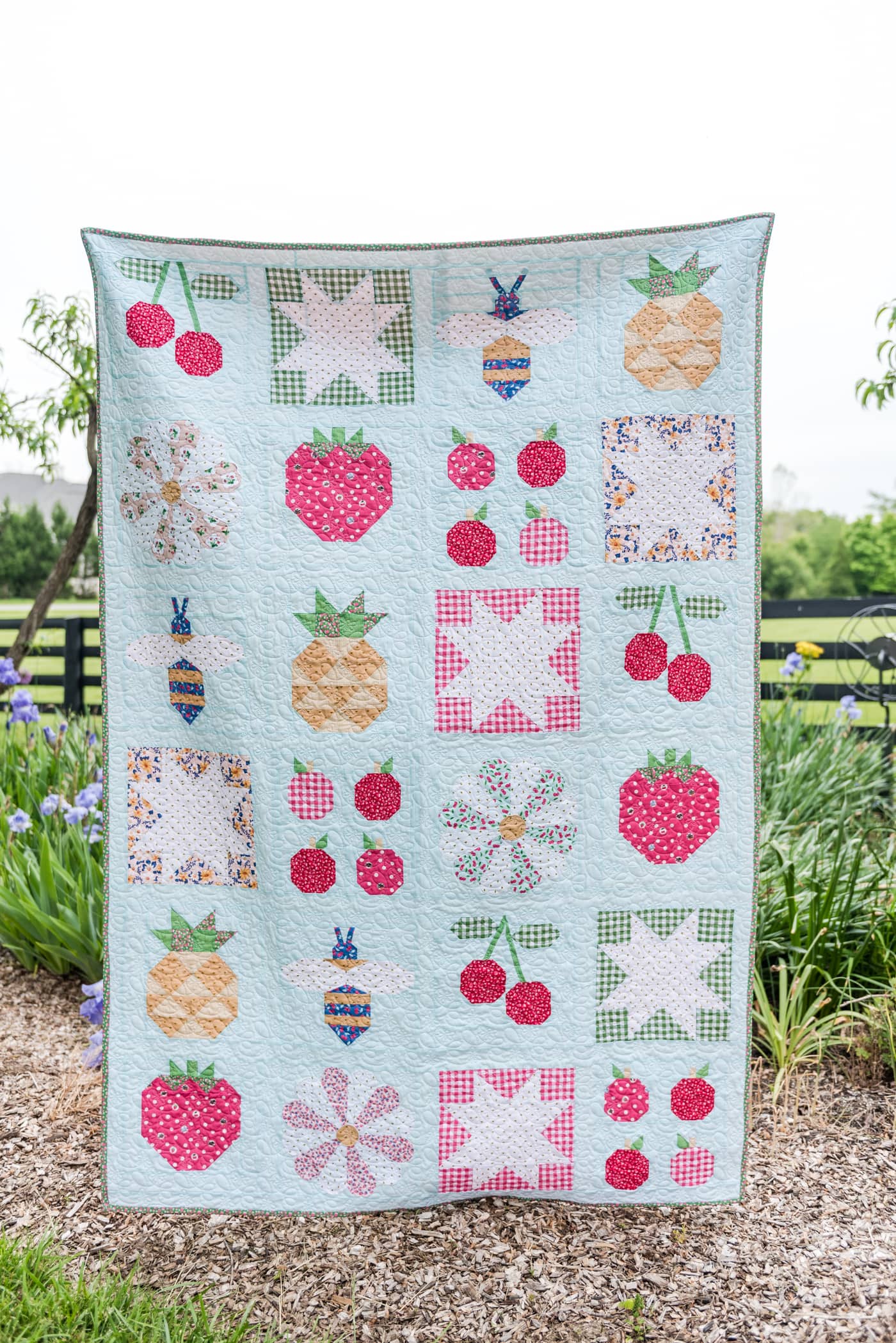 quilt hanging in front of garden