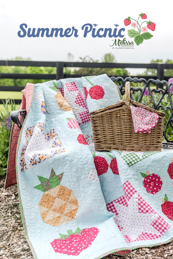 picnic basket and quilt on bench outdoors