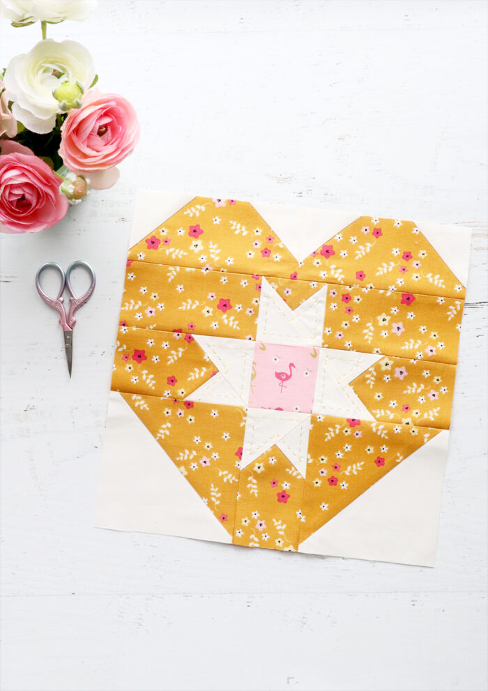 yellow and white heart quilt block on white cutting mat