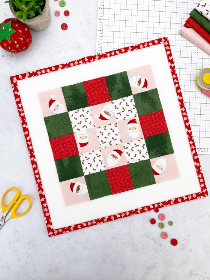 pink, red and green quilt block on white cutting mat