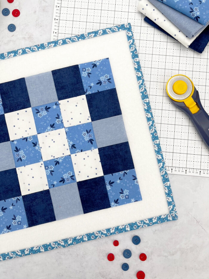 blue and white quilt block on white cutting mat