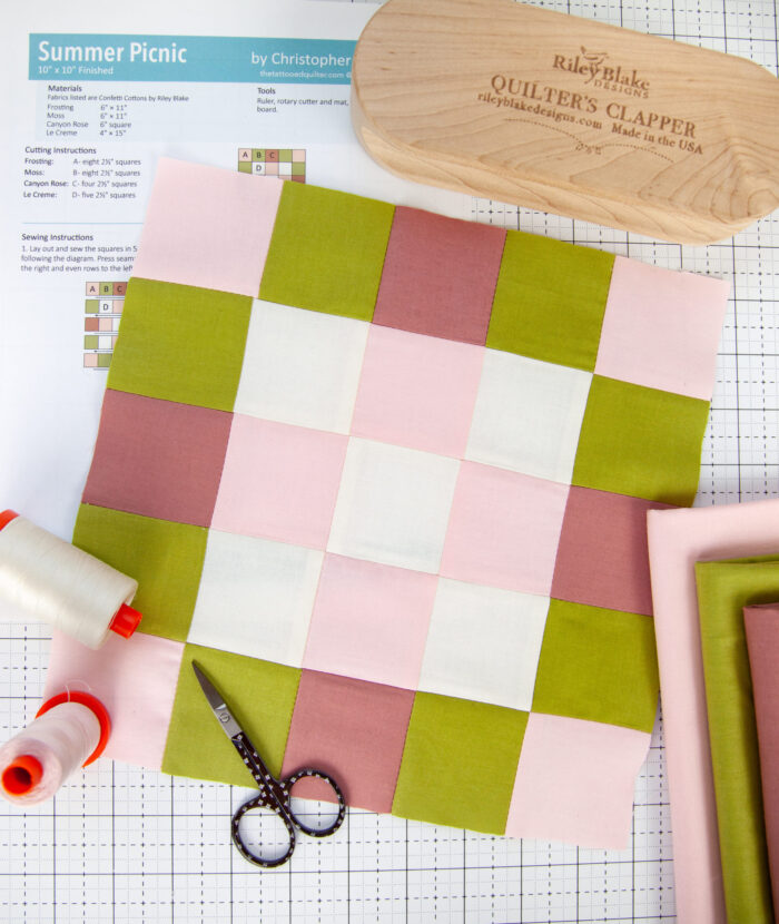 pink, olive and white quilt block on white cutting mat