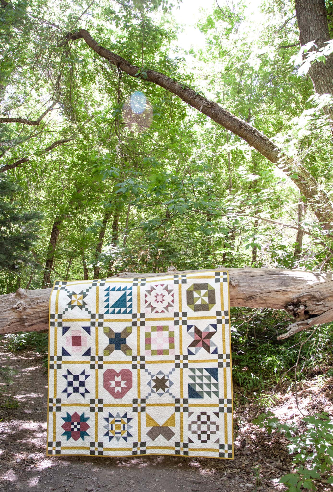 colorful quilt draped over wood log outdoors