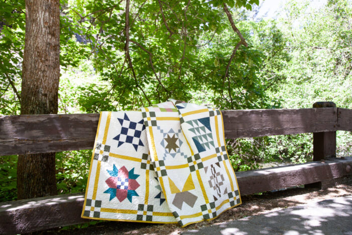 colorful quilt draped over wood fence outdoors