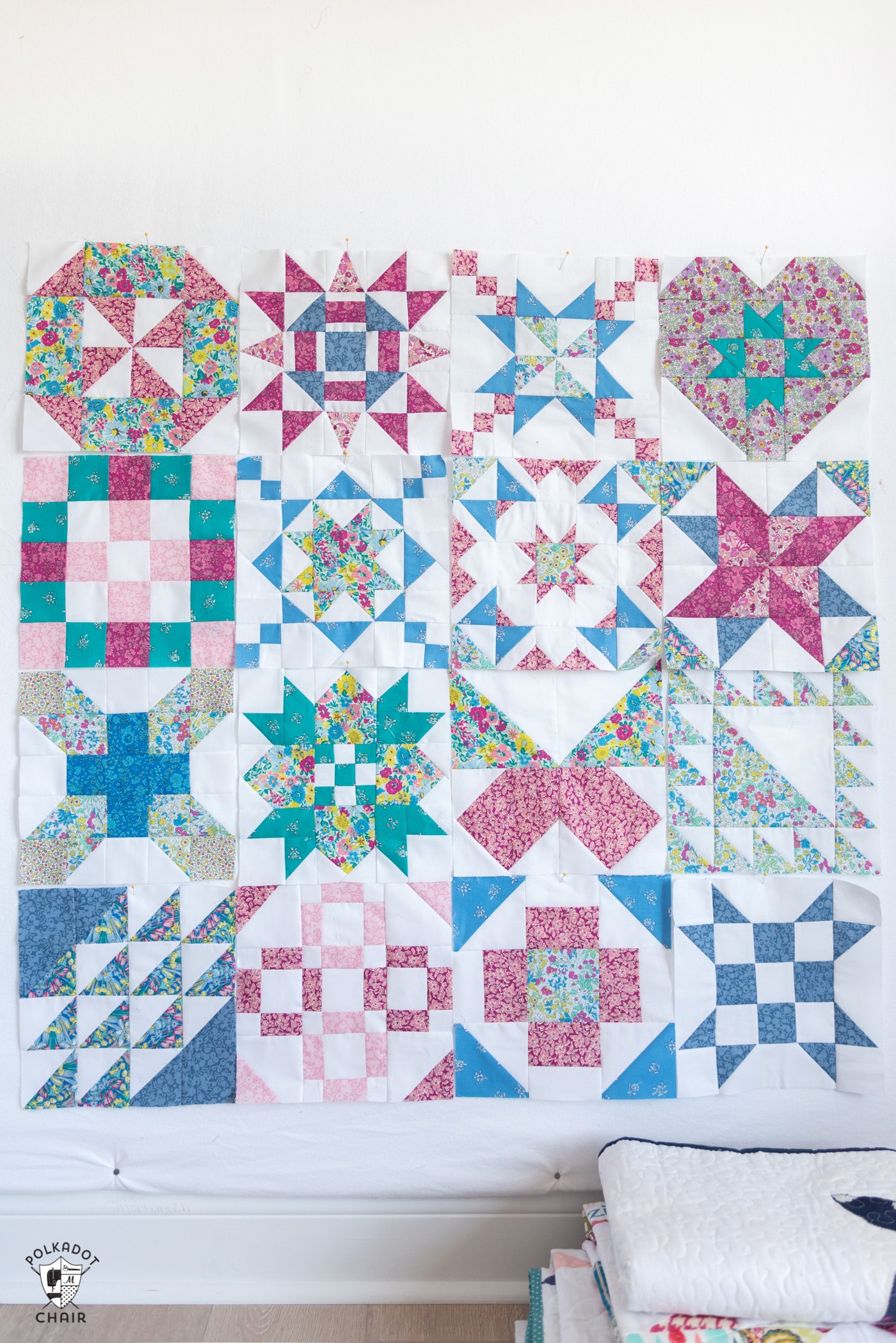 pink, blue and white quilt blocks on white wall
