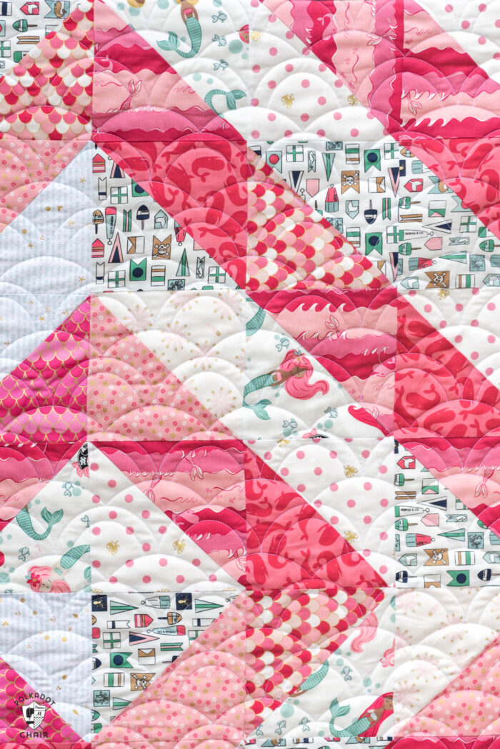 close up of coral and white baby quilt