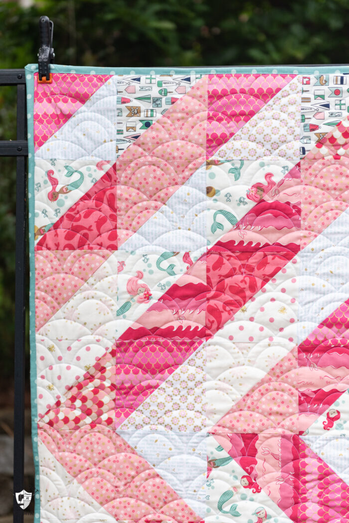 close up of coral and white baby quilt