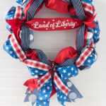 red, white and blue ribbon wreath on white wall