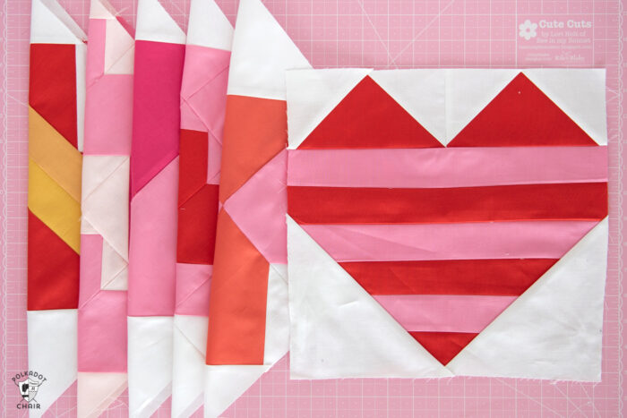 red, white and pink quilt blocks on cutting mat