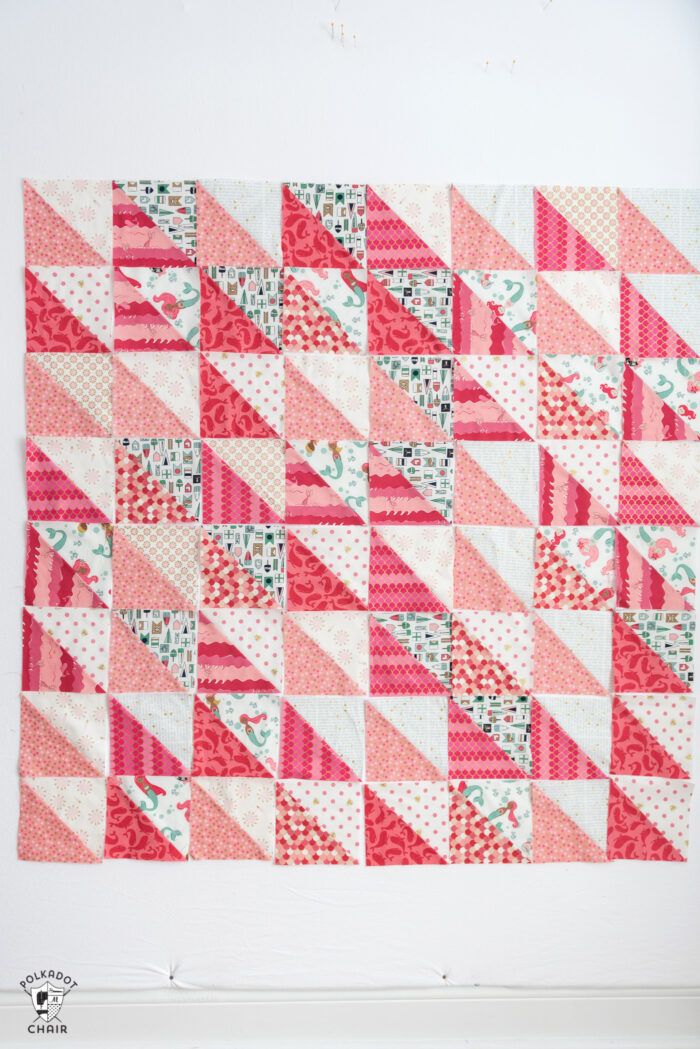 diagram of coral and white half square triangle quilt blocks arranged into 8 rows of 8 squares